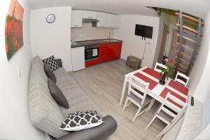a living room and kitchen with a couch and a table at Apartment April in Bled +8 photos