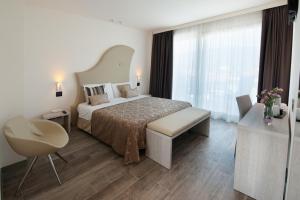 1 dormitorio con cama, escritorio y silla en Hotel Italia, en Garda