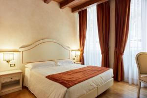 um quarto com uma cama e uma janela grande em Albergo Mazzanti em Verona