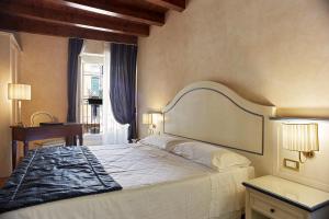 um quarto com uma cama, uma escrivaninha e uma janela em Albergo Mazzanti em Verona