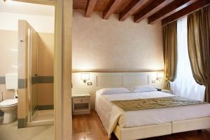 um quarto com uma cama grande e um WC em Albergo Mazzanti em Verona