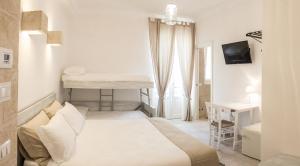 a white bedroom with a bed and a desk and a table at Bed & Breakfast AMATI in Fasano