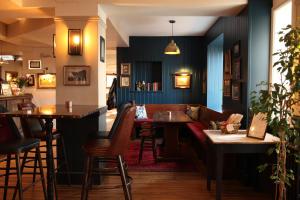 a bar with tables and chairs in a restaurant at The Jug And Bottle in Heswall