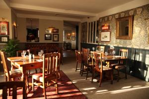 a dining room with wooden tables and chairs at The Jug And Bottle in Heswall