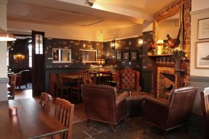 a restaurant with a table and chairs and a fireplace at The Jug And Bottle in Heswall