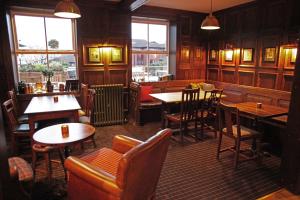 a restaurant with tables and chairs and a bar at The Jug And Bottle in Heswall