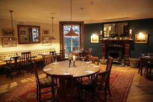 a dining room with a table and chairs and a fireplace at The Jug And Bottle in Heswall