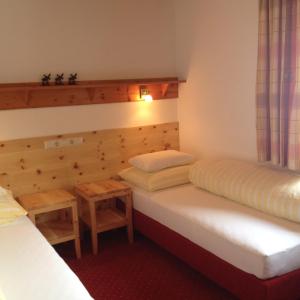 Habitación con 2 camas y 2 mesas en Appartements Birkenhof, en Lech am Arlberg