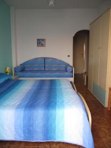 1 dormitorio con 1 cama grande y edredón azul en B&B Casa Antonio en Isquia