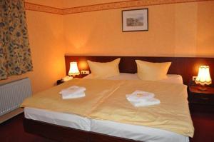 a hotel room with a bed with towels on it at Hotel Rügen Park KG in Gingst