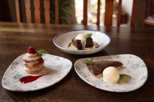two plates of desserts on a wooden table at The Jug And Bottle in Heswall