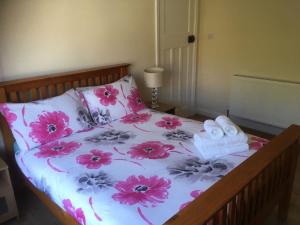 a bed with pink flowers and towels on it at Central Location Preston 1 in Preston
