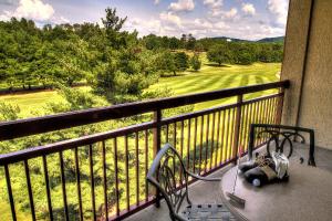 a bench on a balcony with a view of a golf course at RiverStone Condo Resort & Spa in Pigeon Forge