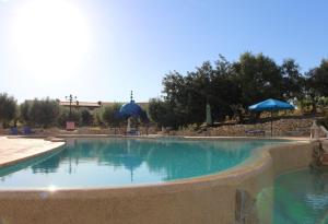 a swimming pool with blue water in a resort at Hotel de Charme Capela das Artes in Armação de Pêra