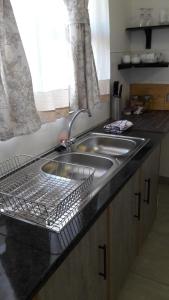 a kitchen sink with a dish drying rack next to it at Self-catering Studio, Unit 6 on Krupp in Windhoek