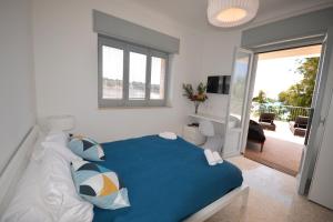1 dormitorio con cama azul y balcón en Luxury Beach Villa Puglia Italy, en Pulsano