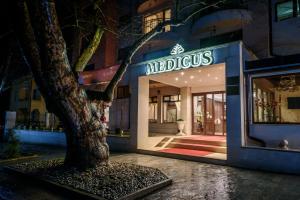 a building with a tree in front of a store at SPA Hotel Medicus in Varshets