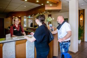a man and a woman standing at a counter at City Hotel Aschersleben in Aschersleben