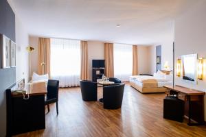 a hotel room with a bed and a living room at City Hotel Aschersleben in Aschersleben +43 photos
