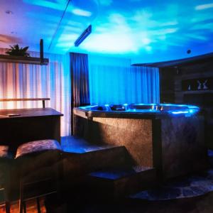 Cette chambre dispose d'une baignoire avec des lumières bleues. dans l'établissement La vie Deluxe - Private Luxury Apartments, à Campo Tures