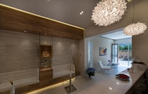 a living room with two chandeliers and a couch at Artemide Hotel in San Vito lo Capo