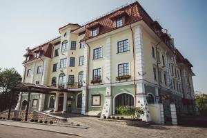 duży biały budynek z oknami wychodzącymi na ulicę w obiekcie Hermitage Hotel w Brześciu