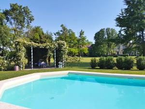 a large blue swimming pool in a yard at Villa Maffei Rizzardi in Oppeano