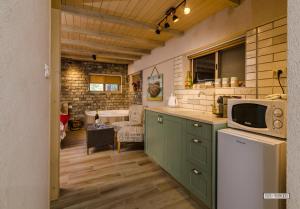 a kitchen with green cabinets and a microwave at Dream Cabin in Tiberias