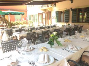 un comedor con mesas y sillas blancas en Locanda da Bepi, en Marano di Valpolicella