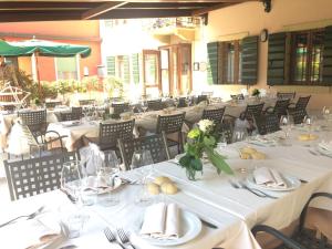 a dining room with white tables and chairs at Locanda da Bepi in Marano di Valpolicella