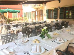 a dining room with white tables and chairs at Locanda da Bepi in Marano di Valpolicella