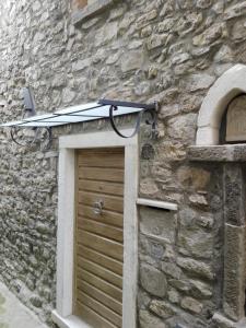 フォズディノーヴォにあるIl piccolo nidoの石造りの建物の上にサーフボード付きの扉
