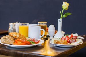 a table with two plates of food and orange juice at Elite Hotel Savoy in Malmö