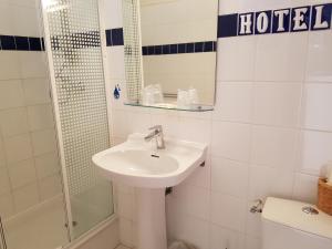 a bathroom with a sink and a shower and a toilet at Hôtel Des Poètes avec parking sur réservation in Béziers