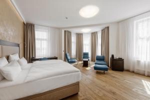 a hotel room with a large bed and two chairs at Theresian Hotel in Olomouc