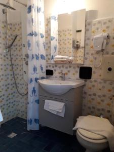 een badkamer met een wastafel, een toilet en een douche bij Hotel Nautilus in Valmadrera