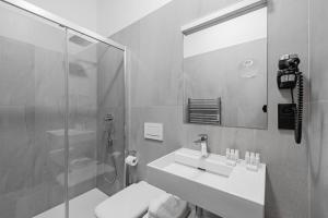 a bathroom with a sink and a shower and a mirror at Theresian Hotel in Olomouc