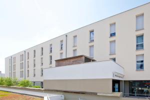 un grande edificio bianco con una grande facciata bianca di Séjours & Affaires Rennes Longs Champs a Rennes