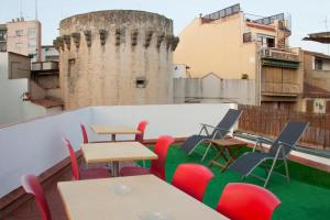 eine Terrasse mit Tischen und Stühlen auf dem Dach in der Unterkunft Hostal Portofino in Arenys de Mar