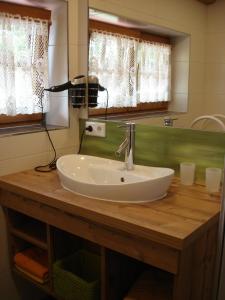 a white sink on a wooden counter in a bathroom at Landhaus Wiederkehr in Ramsau am Dachstein