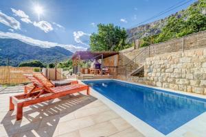 a villa with a swimming pool with mountains in the background at Holiday Home Marincello in Solin