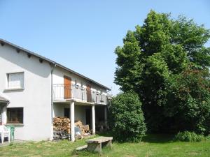 una casa blanca con un árbol y un banco en Camping du Meygal, en Saint-Julien-Chapteuil