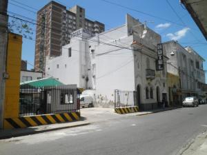 an empty city street with a white building and a gate at Emperatriz HOTEL FAMILIAR in Santa Fe