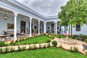 - une vue sur l'extérieur d'une maison avec un jardin dans l'établissement Casa Azul Monumento Historico, à Mérida