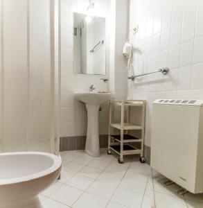 a white bathroom with a sink and a toilet at Hostel Carvalho in Mondim de Basto