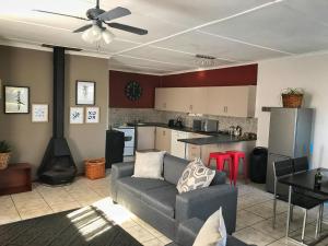 a living room with a couch and a kitchen at Take a Break Self Catering Accommodation in Knysna