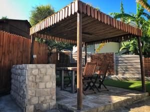 a wooden pergola with a table and chairs under it at Take a Break Self Catering Accommodation in Knysna