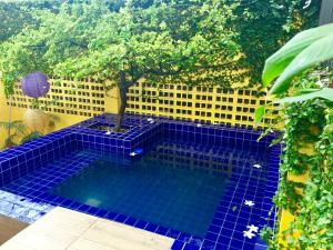 a swimming pool with a tree in the middle at Cosmopolitan Hostel in Recife