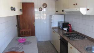 a small kitchen with a stove and a microwave at Apartamento Alegria in Santiago de Compostela