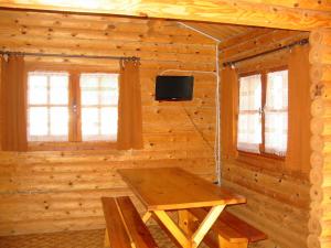 a wooden cabin with a table and a tv in it at Camping du Meygal in Saint-Julien-Chapteuil